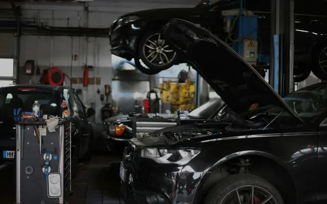 Black Audi with the bonnet open in a European workshop